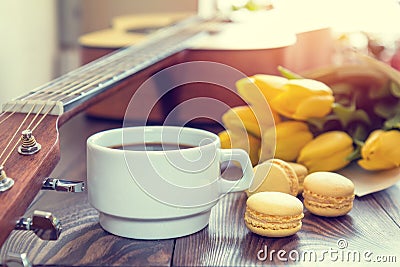 Beautiful spring music background. Cup of coffww, guitar, yellow Stock Photo