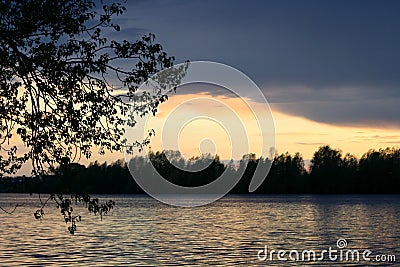 Spring sunset on the river with a beatiful sky in pastel colors and silhoettes of trees. Stock Photo