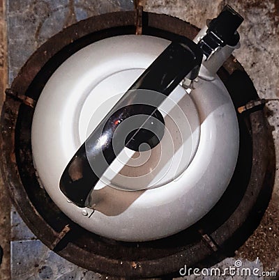 beautiful stainless kettle on a round gas stove seen from above Stock Photo