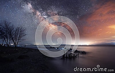 Beautiful starry sky with bright milky way galaxy over the lake. Night landscape . Stock Photo