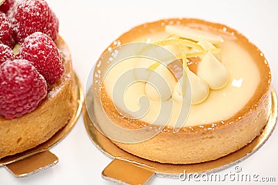 Still life composition with French baked tartlet with lemon meringue and partial view of raspberry cake, isolated white Stock Photo