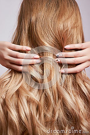 Beautiful strong hair of a woman, strengthening and restoring the hair roots. Beautiful manicure on the hands of a girl Stock Photo