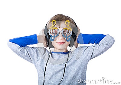 Beautiful stylish blond child wearing big professional headphones and funny glasses listens to music Stock Photo