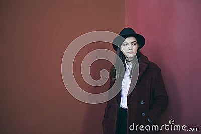 Beautiful stylish teenager girl in hat and red fur coat. Red calm sadness mood. problem solving. Fashion street style Stock Photo