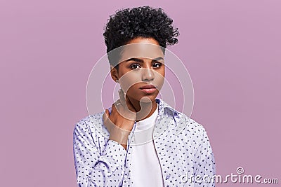 Beautiful stylish young African American woman with dark curly bushy hair enjoys summer rest, has the serious and Stock Photo