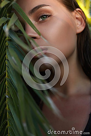 Beautiful summer girl in sunset. young sexy woman in palm leaves Stock Photo