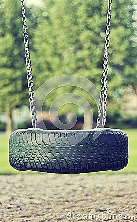 Beautiful summer season specific photograph. Old car tire used as a swing for children. Play time theme Stock Photo