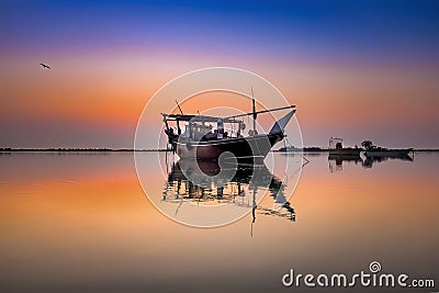 Beautiful Sunrise Boat in seaside with red and dark sky. Dammam -Saudi Arabia Stock Photo