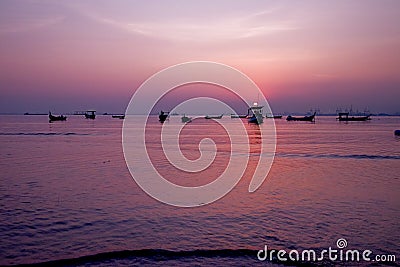 Beautiful sunrise. Fishing boat silhouette with orange sunrise sky and water reflection Stock Photo