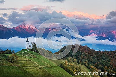 Beautiful sunrise landscape of church Jamnik in Slovenia with cloudy sky Stock Photo