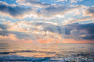 Beautiful sunrise over the sea. Sun beams break through the clouds. Stock Photo