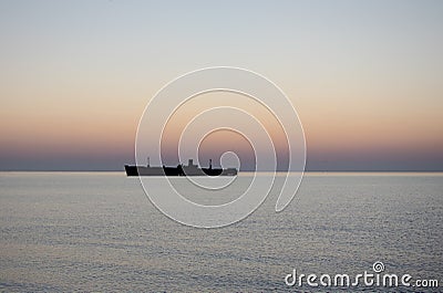 Beautiful sunrise at sea. The silhouette of an abandoned wreck in the sea Stock Photo