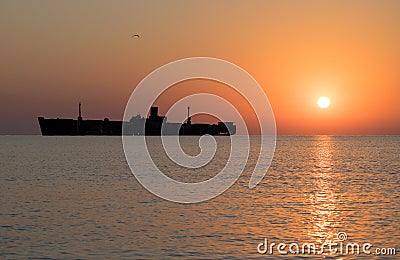 Beautiful sunrise at sea. The silhouette of an abandoned wreck in the sea Stock Photo