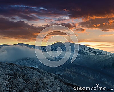 Beautiful sunrise in the winter mountains. Dramatic cloudy over sky. Stock Photo