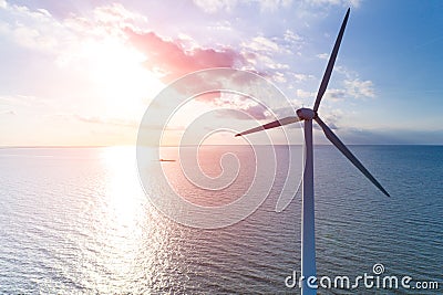 Sunset above the windmill in the ocean Stock Photo