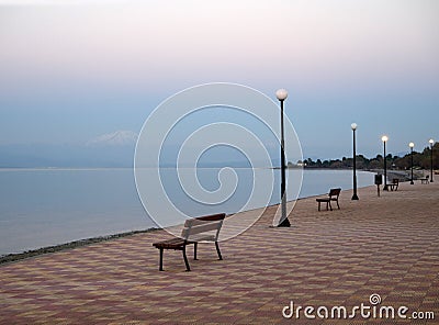 Beautiful sunset and bench on the seafront in Greece Stock Photo