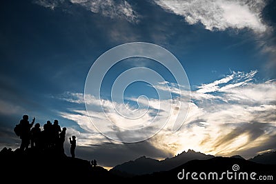 Beautiful sunset in the mountains with the outlines of people Stock Photo