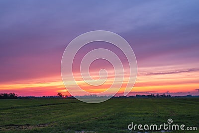 Beautiful sunset with a multi coloured sky over a Dutch agricultural polder landscape Stock Photo