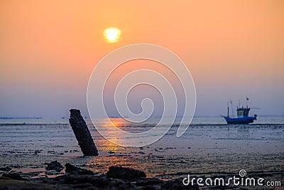 Beautiful sunset with old rusty fishing boat parked on a sandy Stock Photo