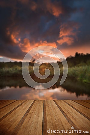 Beautiful sunset over Autumn Fall lake with crystal clear reflections with wooden planks floor Stock Photo