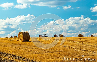 Beautiful sunset over farm field with many hay bales with blue sky and colorful clouds in background Stock Photo