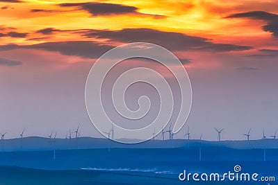 Beautiful sunset over the hills with wind turbines Stock Photo