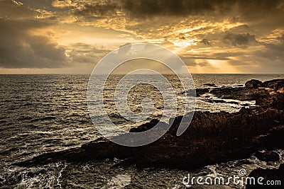 Beautiful sunset over the rocky beach of Gokarna called OM beach in Karnataka, India. Stock Photo