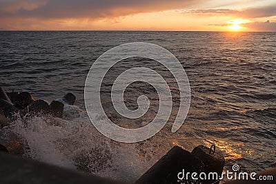 Beautiful sunset on the shore of a sandy beach. Waves on the Baltic Sea. Stock Photo