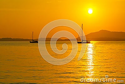 Beautiful sunset and silhouette sailing boats Stock Photo