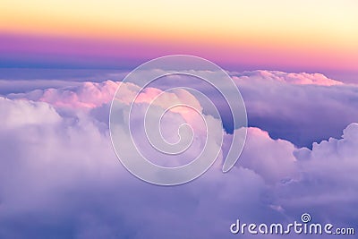 Beautiful sunset sky above clouds with nice dramatic light. View from airplane window Stock Photo