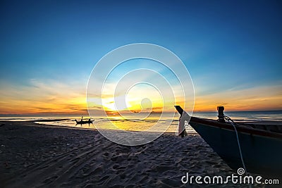 Beautiful sunset sunrise background on the beach with silhouette boat in the foreground Stock Photo