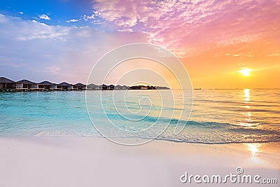 Beautiful sunset at tropical resort with overwater bungalows Stock Photo