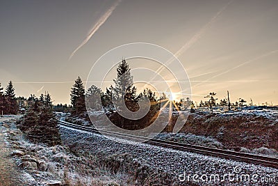Beautiful sunset view in the background of an old empty railroad covered with snow Stock Photo