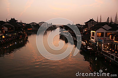 Beautiful sunset in Zhujiajiao ancient town, China. Traditional chinese arhitecture, ships on water, river Stock Photo