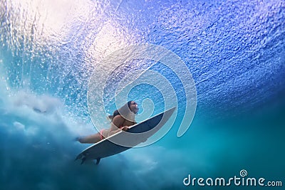 Beautiful surfer girl diving under water with surf board Stock Photo