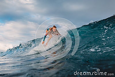 Beautiful surfer girl on surfboard. Woman in ocean during surfing. Surfer and barrel wave Stock Photo