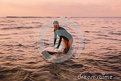 Beautiful surfgirl on a surfboard in ocean. Stock Photo