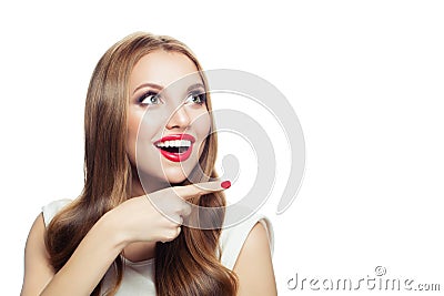 Beautiful surprised model woman smiling and pointing finger isolated on white background Stock Photo