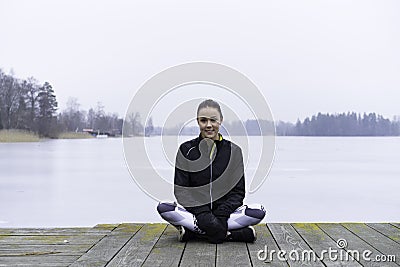 Beautiful Swedish caucasian fitness teen girl sitting on wood bridge outdoor in winter landscape Stock Photo