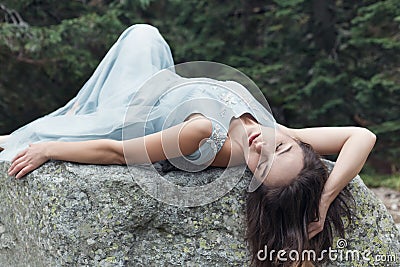 Beautiful sweet girl bride in her wedding dress light air in the mountains near the lake, a beautiful landscape of mountains Stock Photo