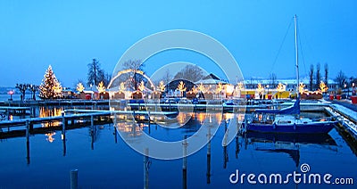 Beautiful swiss christmas market in switzerland on the lake shore with snow covered ships at the blue hour Stock Photo