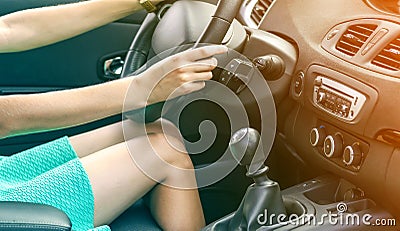 Beautiful tanned slim woman driver legs in a car. Girl in dress driving a car Stock Photo