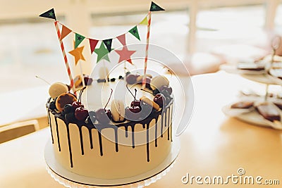 Beautiful tasty birthday cake and gifts on light background. Stock Photo