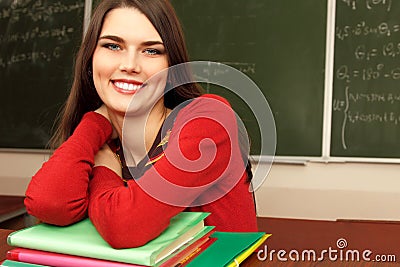 Beautiful teen achiever in classroom near desk happy smiling Stock Photo