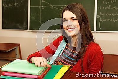 Beautiful teen girl high achiever in classroom near desk happy s Stock Photo