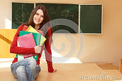 Beautiful teen girl high achiever in classroom near desk happy s Stock Photo