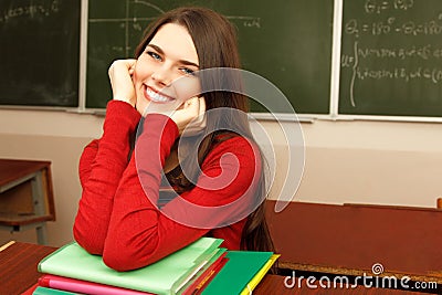 Beautiful teen girl high achiever in classroom over desk happy s Stock Photo