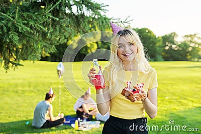 Beautiful teenage girl in a festiv hat on her birthday with a cake and candles. Stock Photo