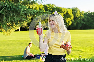 Beautiful teenage girl in a festiv hat on her birthday with a cake and candles. Stock Photo