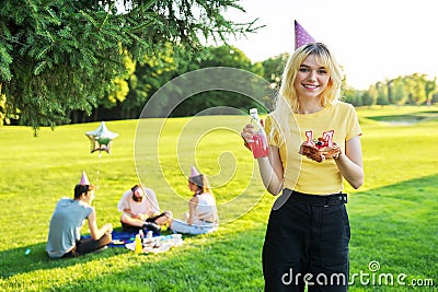 Beautiful teenage girl in a festiv hat on her birthday with a cake and candles. Stock Photo